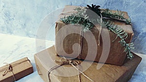 Holiday delivery boxes, parcels wrapped in brown paper, decorated and tied with rough twine, stone background