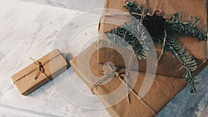 Holiday delivery boxes, parcels wrapped in brown paper, decorated and tied with rough twine, stone background