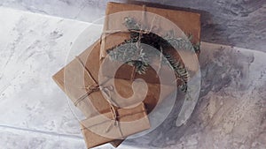 Holiday delivery boxes, parcels wrapped in brown paper, decorated and tied with rough twine, stone background