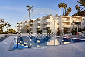 A holiday destination for travelers in Spain. Swimming pool with palm trees and ocean views