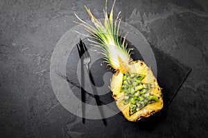 Holiday diet concept or tropical Christmas menu concept. Christmas tree made from pineapple and kiwi on slate board