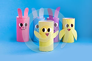 Holiday easy DIY craft idea for kids. Toilet paper roll tube toy\'s rabbit and chick on blue background