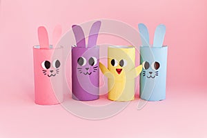 Holiday easy DIY craft idea for kids. Toilet paper roll tube toy\'s rabbit and chick on pink background