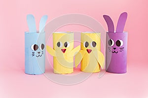 Holiday easy DIY craft idea for kids. Toilet paper roll tube toy\'s rabbit and chick on pink background