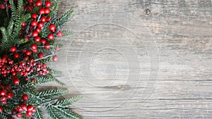 Holiday Evergreen Branches and Berries Over Rustic Wood Background