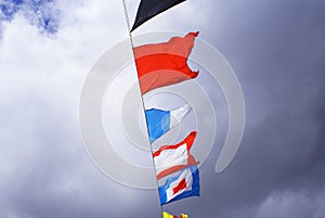 Holiday flags on a rope hanging, fluttering in the wind against the blue sky, holiday.