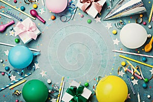 Holiday frame or background with colorful balloon, gift, confetti, silver star, carnival cap, candy and streamer. Flat lay style.