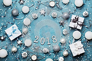 Holiday frame with christmas decoration, gift box, confetti and sequins on vintage blue table top view. Flat lay. New year 2018.