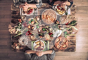 Holiday friends or family at the festive table top view. Friends pray in honor of Easter at the festive table