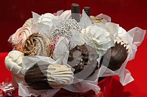 Holiday gift bouquet with sweets on red background.