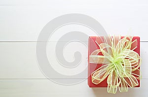 Holiday of gift box with bow ribbon on wooden white table, present of day on wood, top view, vintage retro tone photo