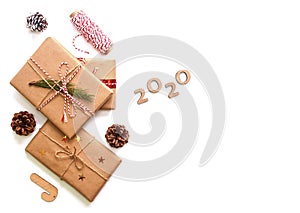 Holiday gift boxes decorated with ribbons and pine cones, 2020 new year numbers isolated on white background