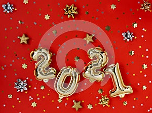 Holiday gold metallic balloon numbers 2021 on red background