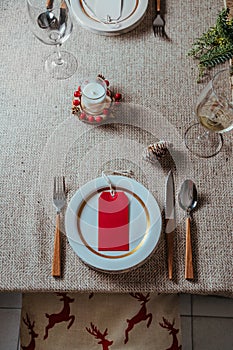 Holiday Gold place setting,  Christmas table with ornaments and natural pine branch on the livingroom home