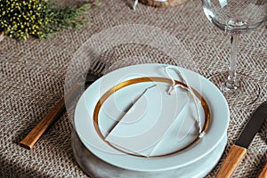 Holiday Gold place setting,  Christmas table with ornaments and natural pine branch on the livingroom home