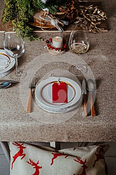 Holiday Gold place setting,  Christmas table with ornaments and natural pine branch on the livingroom home