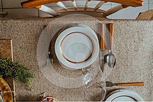 Holiday Gold place setting,  Christmas table with ornaments and natural pine branch on the livingroom home