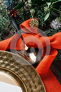 Holiday Gold place setting, decorated with pine branches. wooden background
