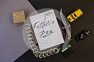 Holiday greeting card for Father`s Day on a black background - the machine, gun, with the text - Happy Father`s Day