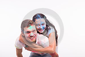 Holiday, holi and people concept - Happy couple having fun covered in paint on white background