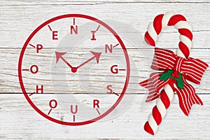 Holiday Hours word message sign with Christmas candy cane