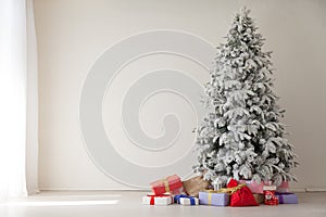 Holiday Interior White Christmas tree with gifts and decorations garlands of lights new year