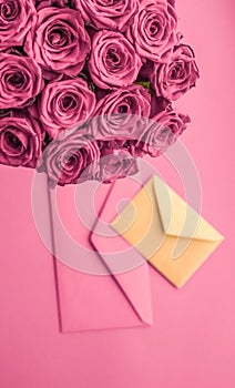 Holiday love letter and flowers delivery, luxury bouquet of roses and card on blush pink background for romantic holiday design