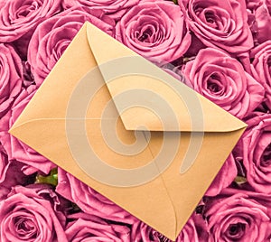 Holiday love letter and flowers delivery, luxury bouquet of roses and card on blush pink background for romantic holiday design