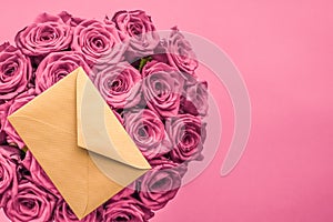 Holiday love letter and flowers delivery, luxury bouquet of roses and card on blush pink background for romantic holiday design