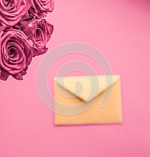 Holiday love letter and flowers delivery, luxury bouquet of roses and card on blush pink background for romantic holiday design