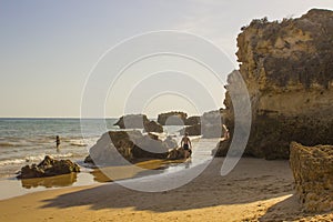 Holiday makers beneath the sedimentary sand stone cliff face on the Praia da Oura beach in Albuferia.