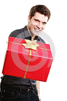 Holiday. Man giving red gift box with golden ribbon