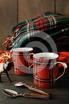 Holiday mugs with hot tea on wood table