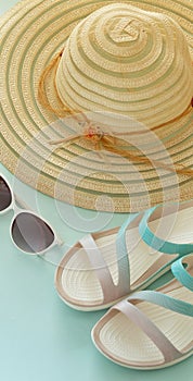 A holiday photo, a summer hat, beach sandals, sunscreen, sun glasses, scallops and souvenir pebbles.  Empty space for an inscripti