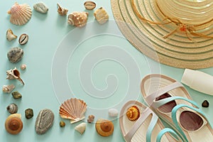 A holiday photo, a summer hat, beach sandals, sunscreen, sun glasses, scallops and souvenir pebbles.  Empty space for an inscripti