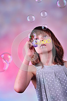 Holiday portrait of happy child blowing soap bubbles