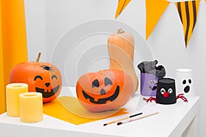 Holiday preparation and handmade party decor. Halloween indoor activity, pumpkin painting