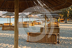 Holiday resort with a beach and sea view with sunshades at sunset