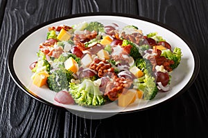 Holiday salad with broccoli, cheese, grapes, bacon, almonds and onions close-up in a plate. horizontal