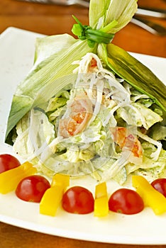 Holiday salad with crab, shrimp and vegetables in leek leaf