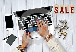 Holiday Sale. Online Shopping. Woman holding credit card and using laptop computer.