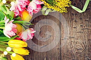 Holiday spring background. Mother`s Day holiday wooden backdrop frame decorated with colorful tulip flowers and mimosa flower