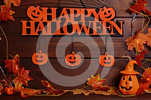 Holiday still life with pumpkins ,leaves,garland, Happy Halloween text on wooden background