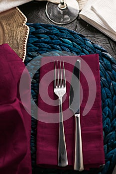 Holiday table setting with purple napkin and silver cutlery, food styling props, vintage set for wedding, event, date, party or
