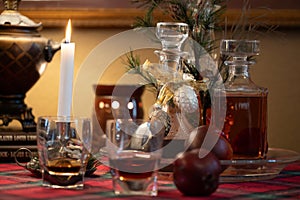 Holiday table with whiskey glasses, decanters abd candle