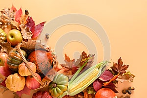 Holiday Thanksgiving Day composition with fall harvest, pumpkins, corncob, colorful falling leaves.