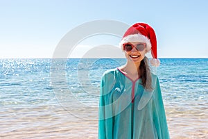 Holiday woman in santa hat relaxing on paradise beach. Christmas vacation