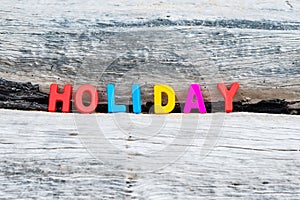 HOLIDAY words on wood background