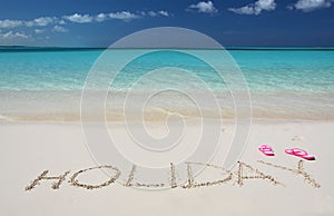 HOLIDAY writing on the sandy beach