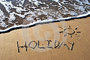 Holiday written in sand